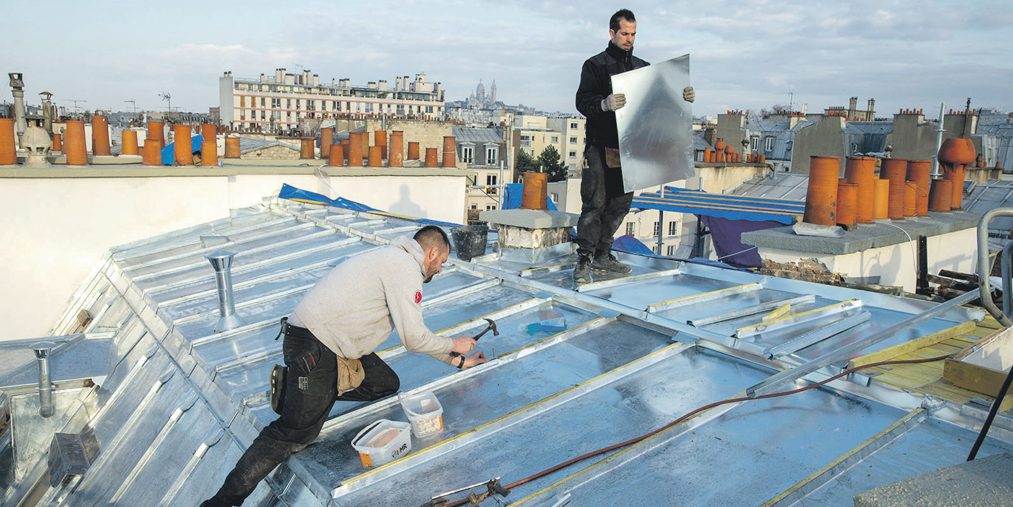 Couvreurs zingueurs posant du zinc sur une toiture